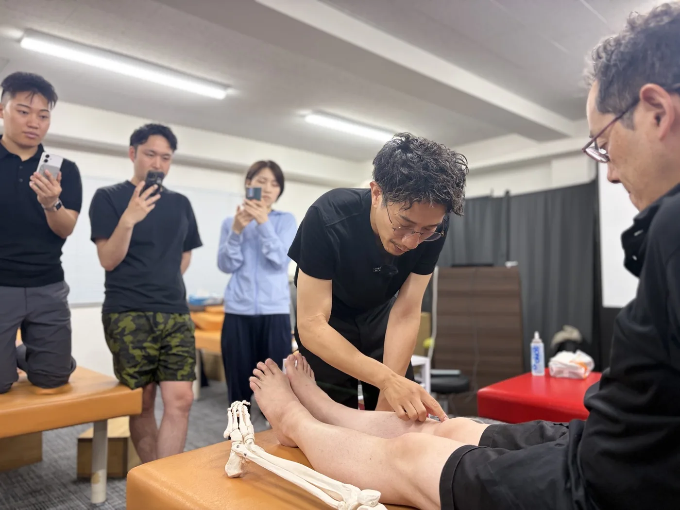 変形性膝関節症など膝の痛みについて医学的根拠をスライドで解説する講義の様子