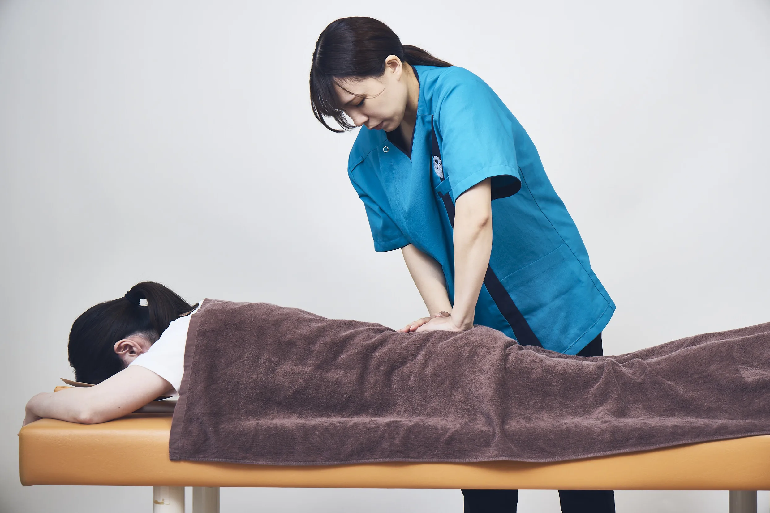 施術室・施術中のイメージ：坐骨神経痛施術の実施シーン